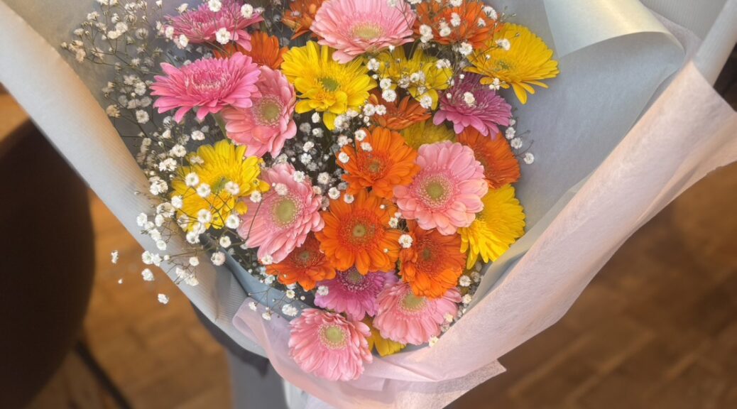 盛岡の花屋が作ったカラフルなガーベラの花束。ピンク・オレンジ・黄色のガーベラとかすみ草を束ねた明るい雰囲気の花束。