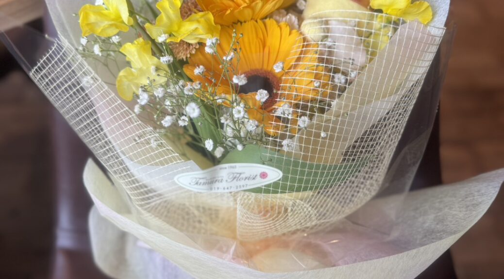 黄色とオレンジの花に犬のマスコットを添えた可愛いマスコット付き花束（田村フローリスト