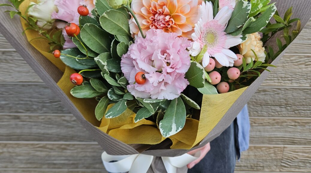 ピンクとオレンジの花に赤い実ものを合わせた秋の花束